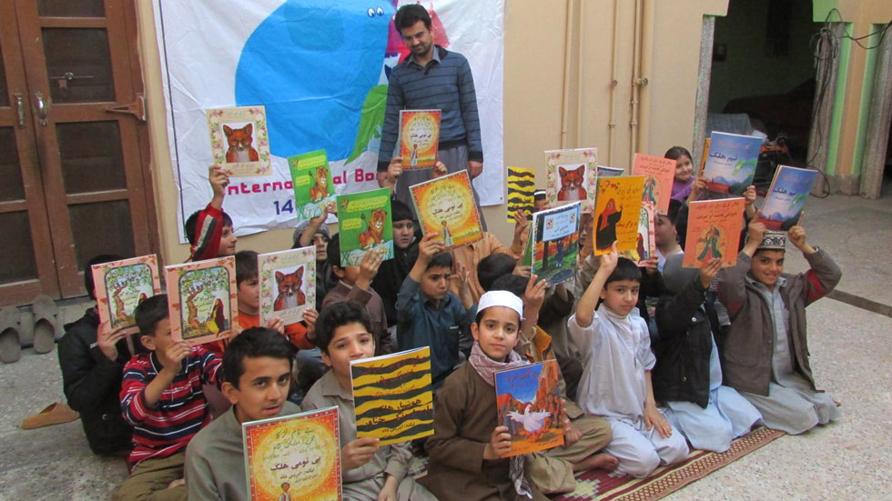 School boys in Pakistan holding up Hoopoe books