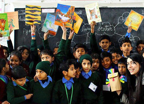 Pakistani kids in a classroom holding up Hoopoe Books
