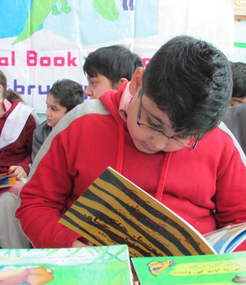 Pakistani Boy reading The Clever Boy and the Terrible, Dangerous Animal at Book Giving event