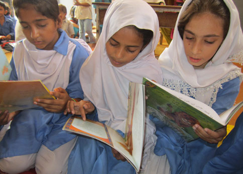 3 Pakistani girls looking through Hoopoe books
