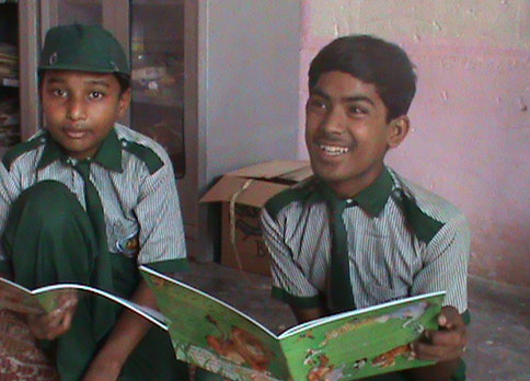 2 boys in Pakistan reading The Lion Who Saw Himself in the Water