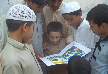 Boys in Pakistan reading the book The Clever Boy and the Terrible, Dangerous Animal