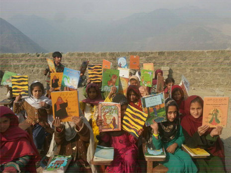 Kids in Pakistan holding up Hoopoe books