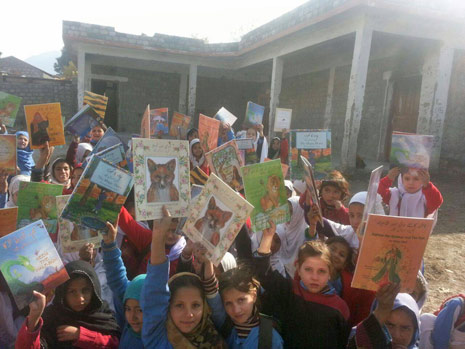 Girls in Pakistan holding up Hoopoe books
