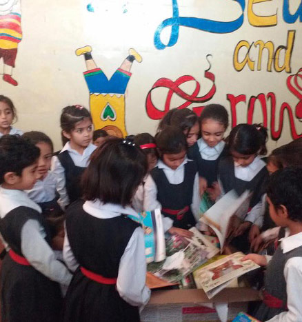 Children looking through a box library from Alif Laila