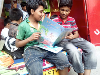 Kids in a Pakistan sharing a Hoopoe book