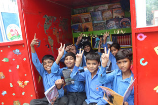 Kids enjoying books from the ALBBS rickshaw library