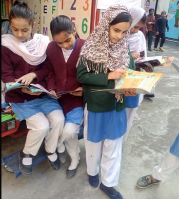 Girls standing near a mobile library with Hoopoe books