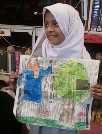 Girl holding up her illustration from The Farmer's Wife